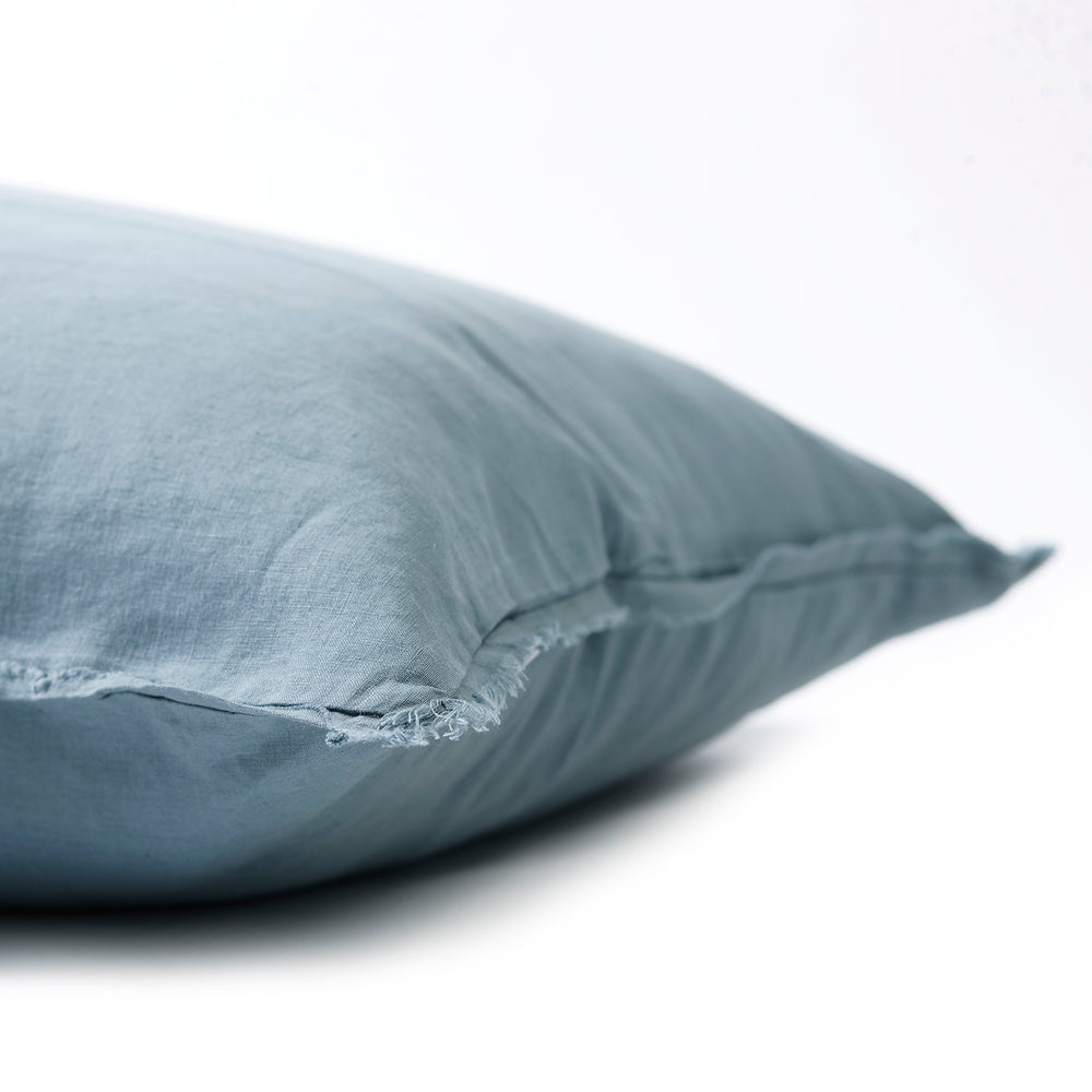 Gentle dusty blue bedhead cushion in stonewashed French flax linen, with hand-tufted edges, offering a muted, serene hue that adds a relaxed, tranquil touch to any room.