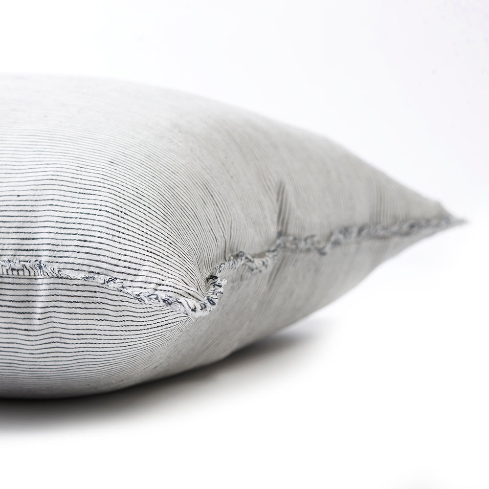 Sleek pinstripe bedhead cushion in stonewashed French flax linen, with hand-tufted edges, offering a sophisticated, modern pattern and a polished, understated look.