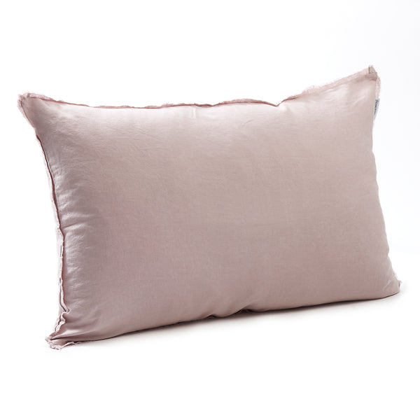 Soft rosewater bedhead cushion in stonewashed French flax linen, with hand-tufted edges, offering a gentle, feminine hue and a serene, calming presence.