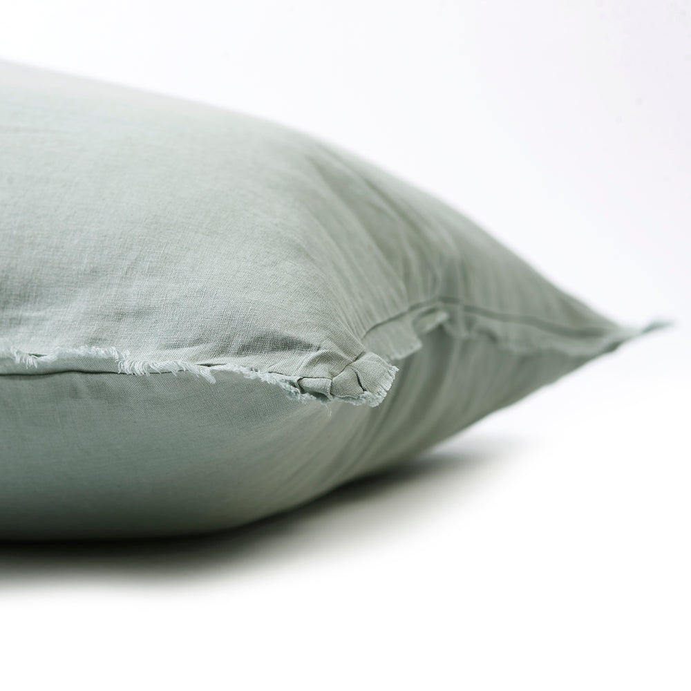 Soft sage green bedhead cushion in stonewashed French flax linen, with hand-tufted edges, offering a tranquil, earthy hue and a serene, natural vibe.